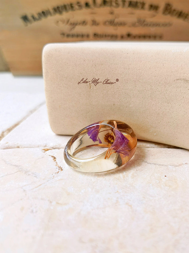 Anillo de resina de flor seca con flores moradas