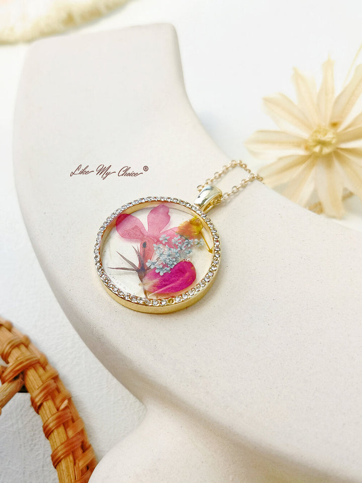 Collier avec pendentif en cristal rond et fleur d'orchidée dansante en résine