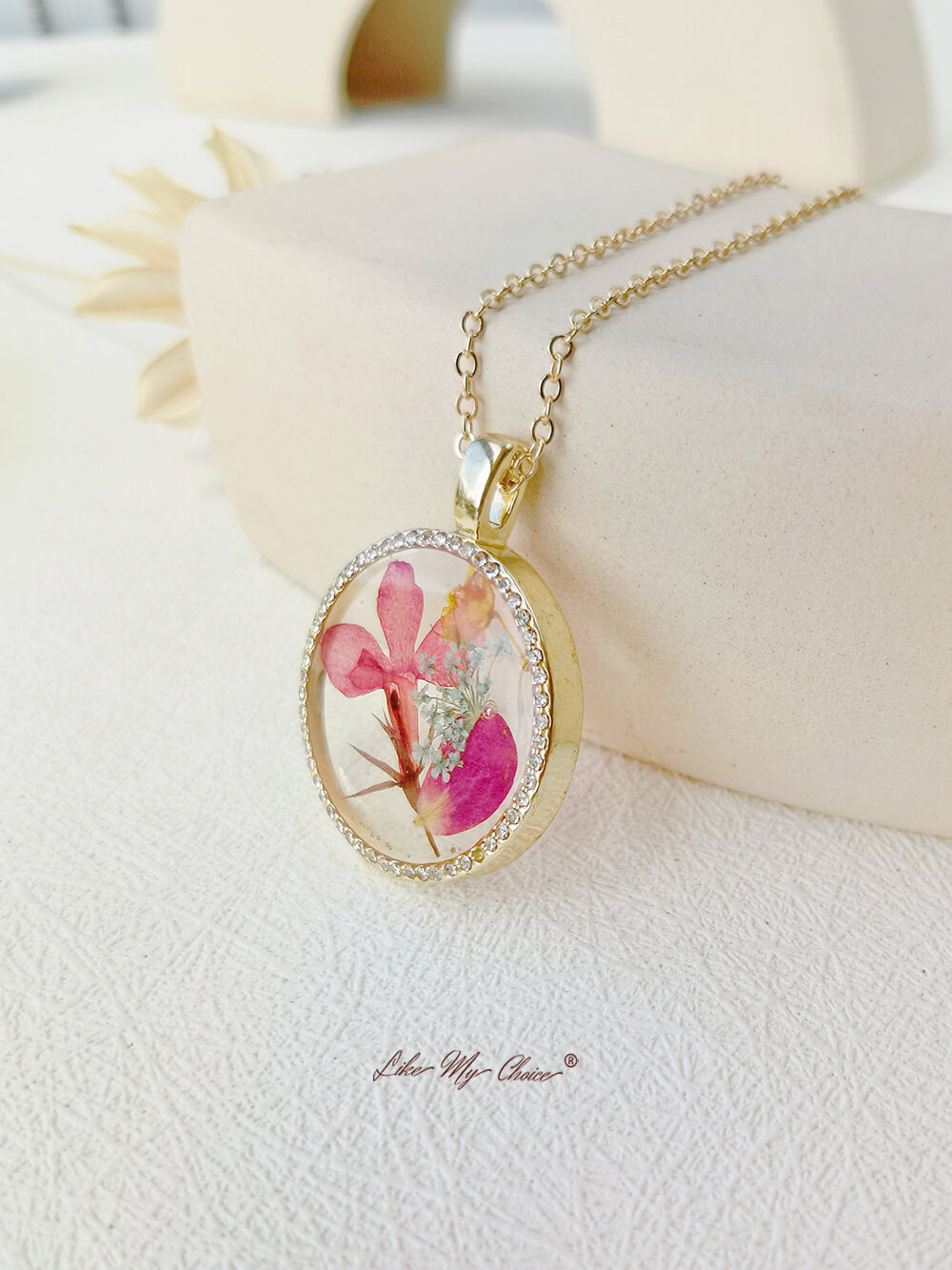 Collier avec pendentif en cristal rond et fleur d'orchidée dansante en résine